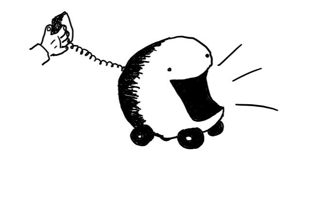 a large round robot with four little wheels and an enormous open mouth. a coiled wire leads from its back which ends in a receiver held by a human hand.