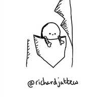 A tiny round robot in the breast pocket of a jacket, positioned with its arms hanging out over the side and its little smiley face poking out.